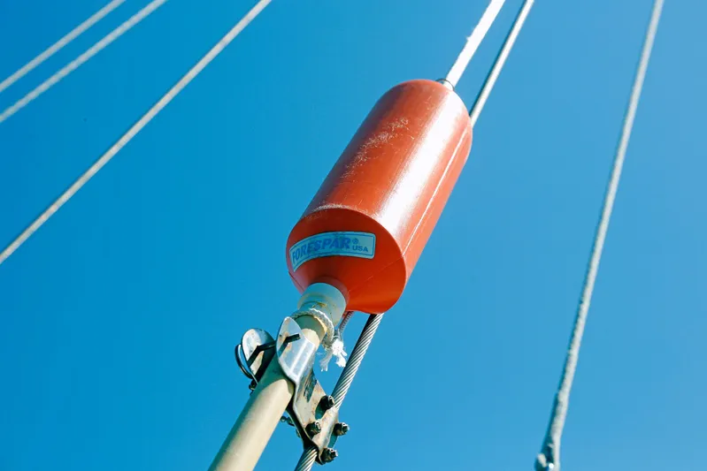 Legacy Yacht Photos Pics Red marine buoy on Hylas 49CC sailboat, 2012 model, against clear blue sky.