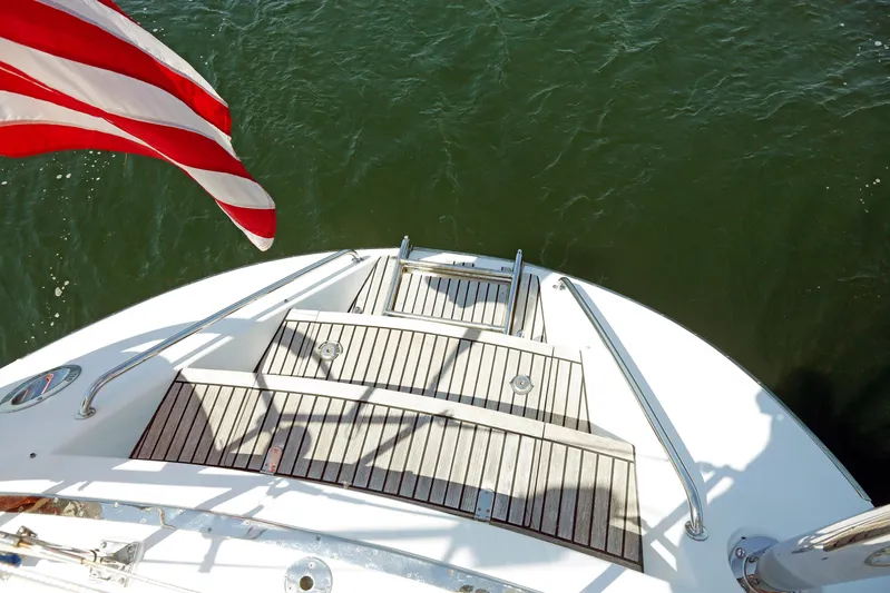 Legacy Yacht Photos Pics Stern view of 2012 Hylas 49CC yacht with American flag over water.