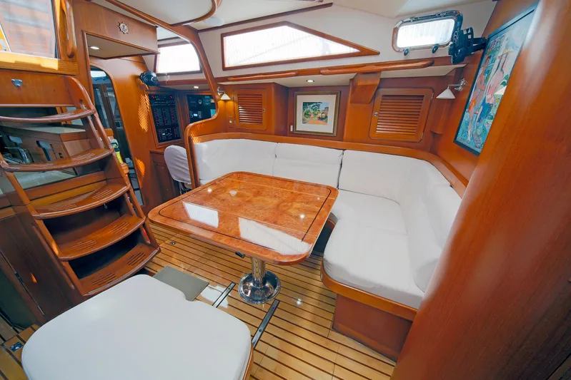 Legacy Yacht Photos Pics Luxurious interior of 2012 Hylas 49CC yacht with wooden finishes and white seating.