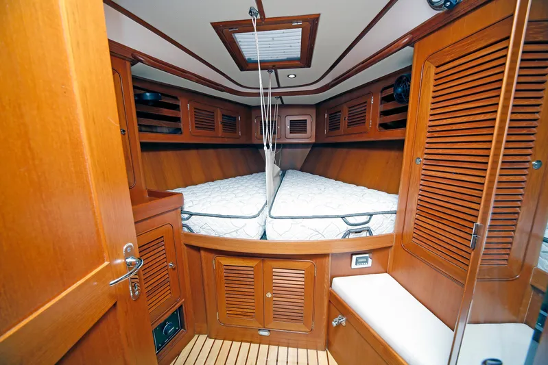 Legacy Yacht Photos Pics Cozy cabin interior of 2012 Hylas 49CC yacht with wooden finish and twin beds.