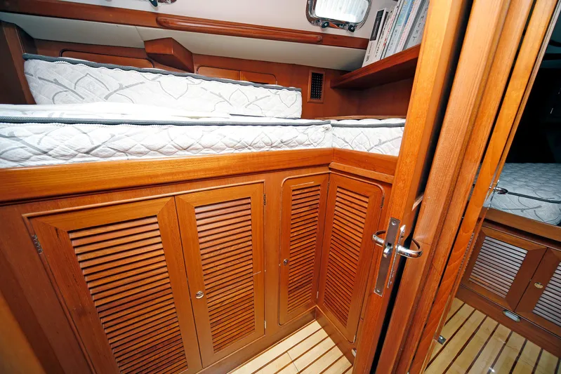 Legacy Yacht Photos Pics Interior of 2012 Hylas 49CC yacht with wooden cabinetry and bunk beds.