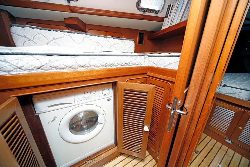 Legacy Yacht Photos Pics Cozy cabin interior of 2012 Hylas 49CC yacht with washer and wooden furnishings.