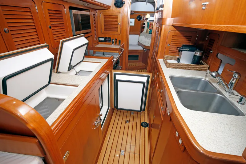 Legacy Yacht Photos Pics Luxurious 2012 Hylas 49CC yacht interior with wooden cabinetry and modern kitchen amenities.