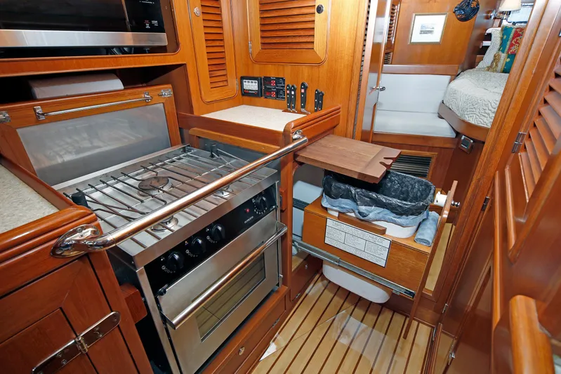Legacy Yacht Photos Pics Compact kitchen area in a 2012 Hylas 49CC yacht with stove and storage.