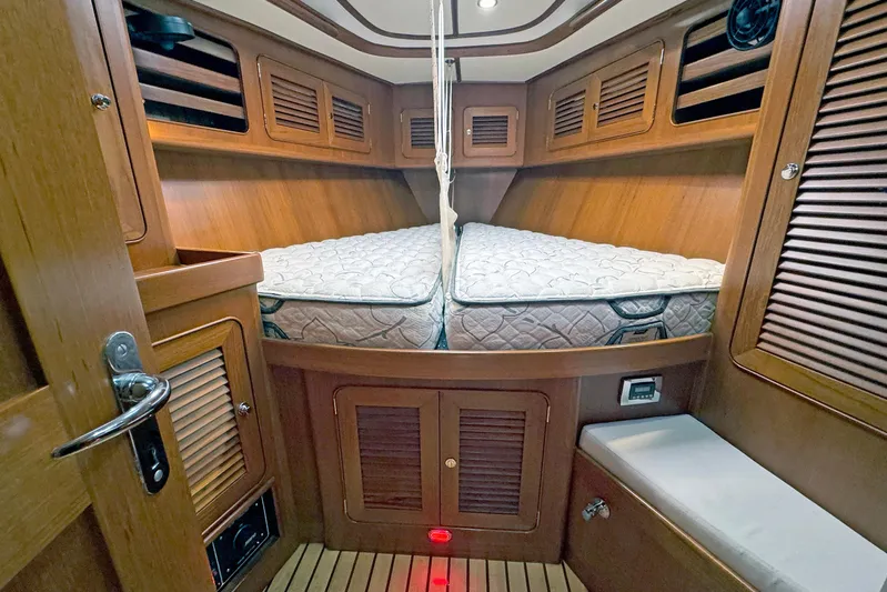Legacy Yacht Photos Pics Cozy cabin interior of 2012 Hylas 49CC yacht with wooden finish and comfortable bedding.