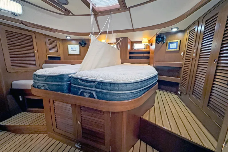Legacy Yacht Photos Pics Luxurious 2012 Hylas 49CC yacht interior with wooden finishes and cozy bedding.