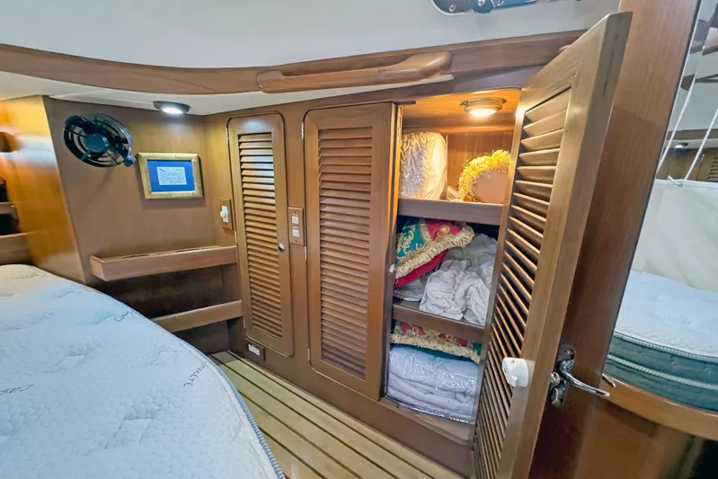 Legacy Yacht Photos Pics Cozy cabin interior of 2012 Hylas 49CC yacht with wooden storage and bedding.