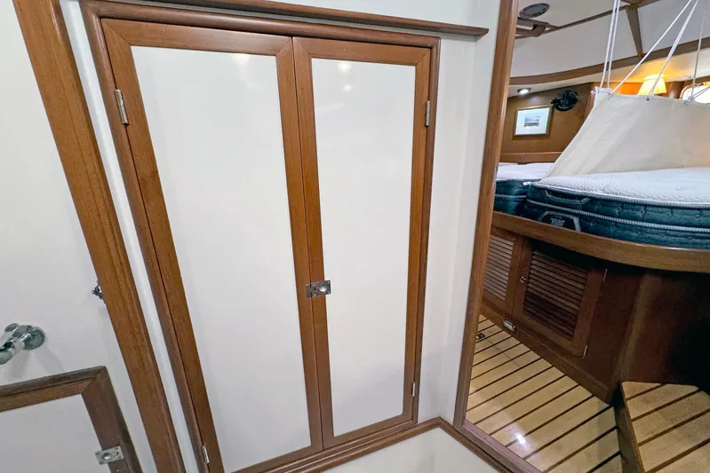 Legacy Yacht Photos Pics Interior of 2012 Hylas 49CC yacht, featuring wooden cabinetry and cozy sleeping area.