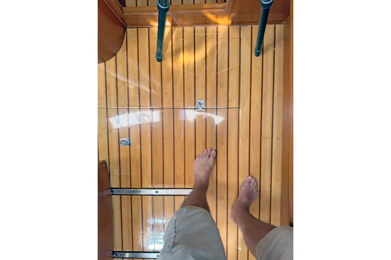 Legacy Yacht Photos Pics Bare feet on polished wooden floor of 2012 Hylas 49CC yacht interior.