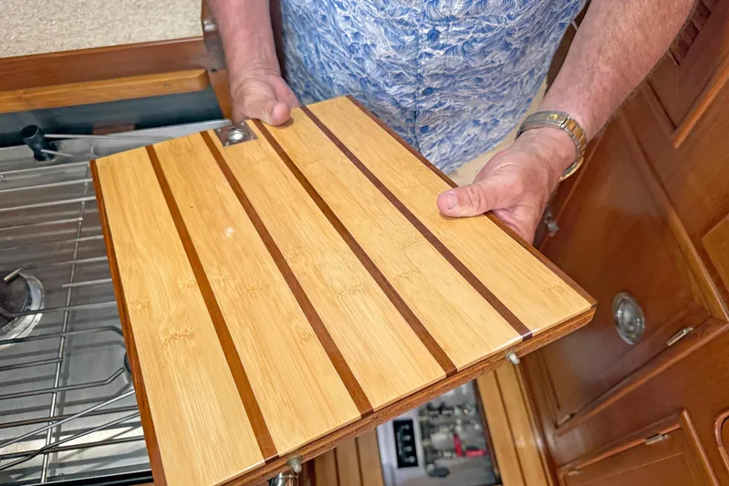 Legacy Yacht Photos Pics Man holding wooden panel in Hylas 49CC yacht kitchen, 2012 model.