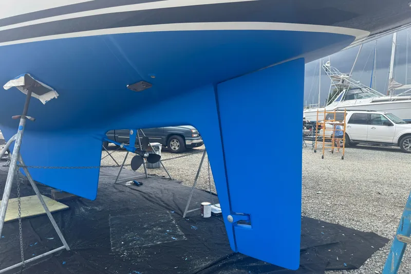 Legacy Yacht Photos Pics Blue hull of a 2012 Hylas 49CC sailboat on stands in a boatyard.