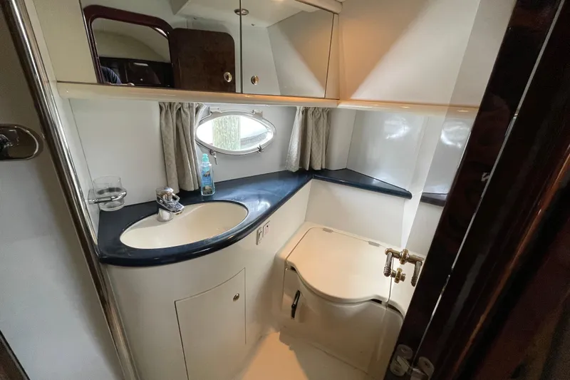 Cover Girl Yacht Photos Pics Bathroom interior of 1997 Sunseeker Camargue 51 yacht, featuring sink and porthole window.