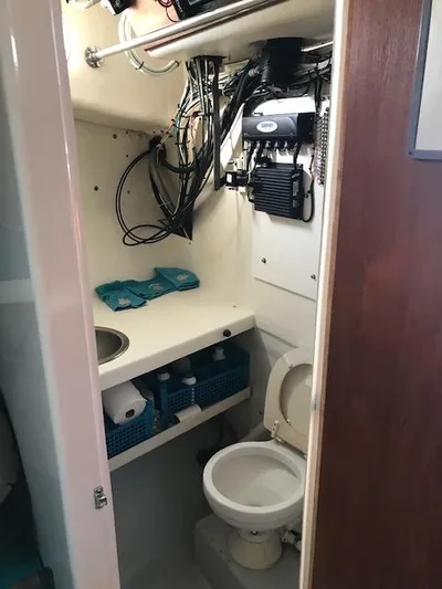 Hey Dad Yacht Photos Pics 1999 Provincial 42 Fishing Boat bathroom with toilet, sink, and storage shelves.