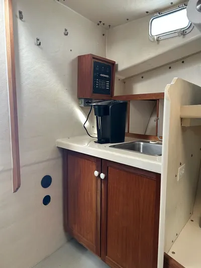 Hey Dad Yacht Photos Pics 1999 Provincial 42 Fishing Boat interior with kitchenette, sink, and wooden cabinets.