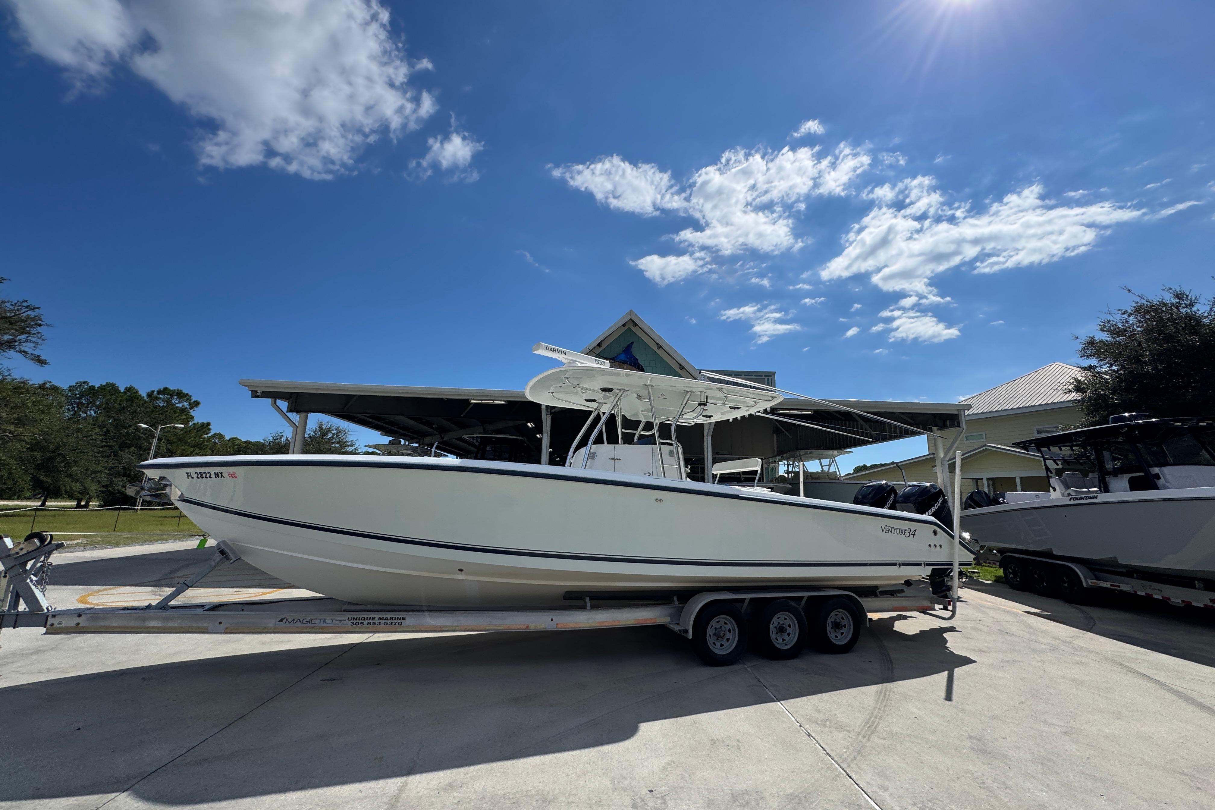 2007 Venture 34 Open boat on trailer under clear blue sky.