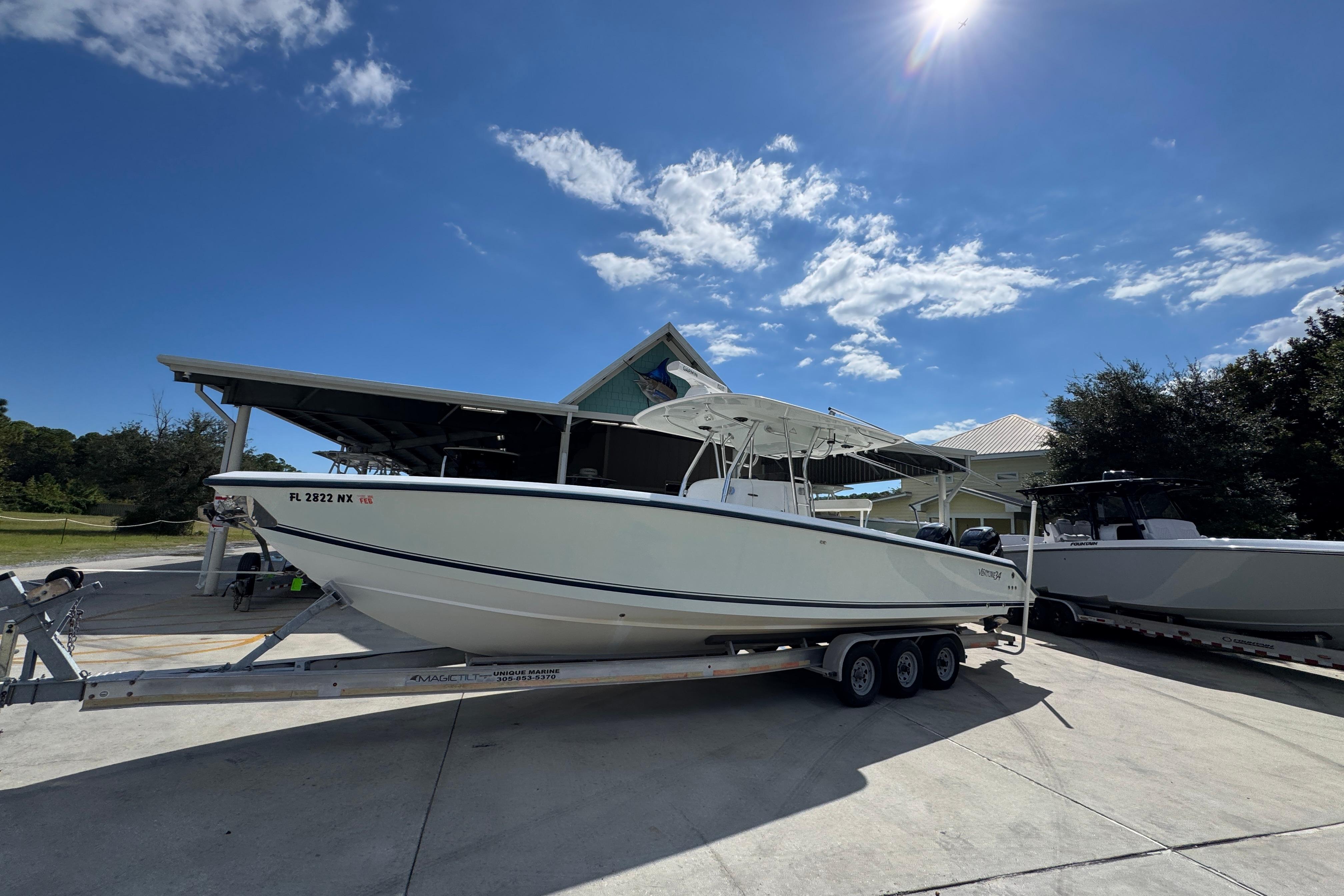 2007 Venture 34 Open boat on trailer under clear blue sky.