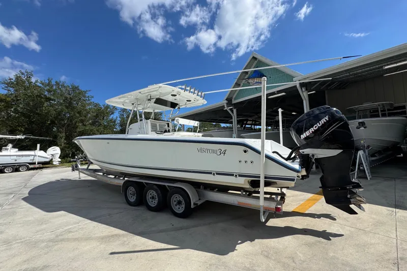  Yacht Photos Pics 2007 Venture 34 Open boat on trailer with Mercury outboard, parked outdoors under blue sky.