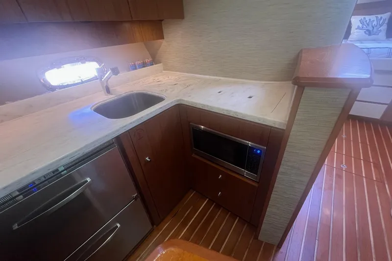  Yacht Photos Pics 2014 Tiara Yachts 3900 Coronet kitchen with sink, microwave, and wooden cabinetry.