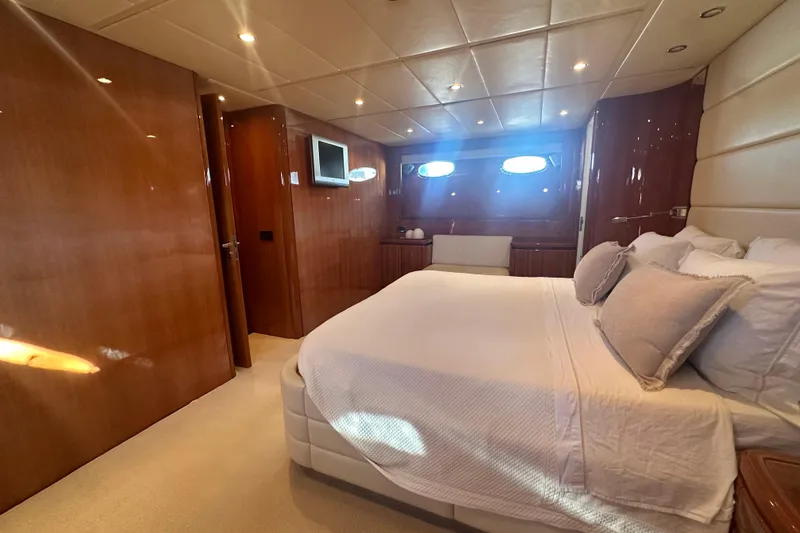 Agios Nikolaos I Yacht Photos Pics Luxurious bedroom interior of 2004 Posillipo Technema 80 yacht with elegant wood paneling.