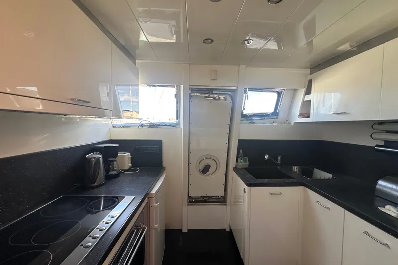 Agios Nikolaos I Yacht Photos Pics Modern kitchen interior on a 2004 Posillipo Technema 80 yacht, featuring sleek countertops and appliances.