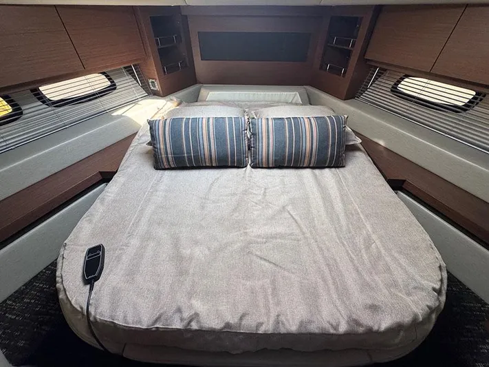  Yacht Photos Pics Luxurious cabin interior of 2015 Sea Ray 510 Sundancer yacht with cozy bed and striped pillows.