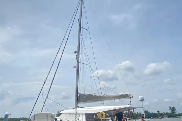 Kaikira Yacht Photos Pics 2019 Nautitech 46 catamaran with sails, docked under a partly cloudy sky.
