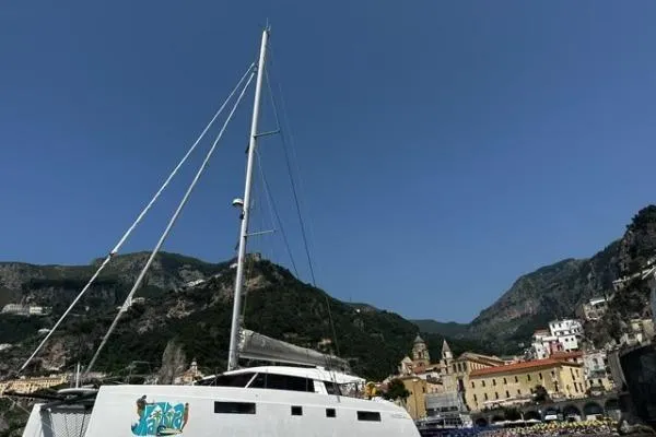 Kaikira Yacht Photos Pics 2019 Nautitech 46 catamaran docked with scenic mountain and town backdrop.