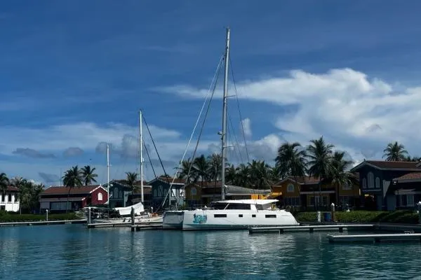 Kaikira Yacht Photos Pics 2019 Nautitech 46 catamaran docked in a tropical marina with colorful houses.