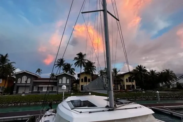 Kaikira Yacht Photos Pics 2019 Nautitech 46 catamaran docked at sunset with colorful sky and palm trees.