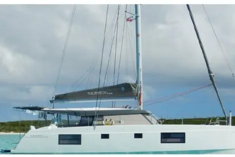 Kaikira Yacht Photos Pics 2019 Nautitech 46 catamaran sailing on turquoise waters under a cloudy sky.