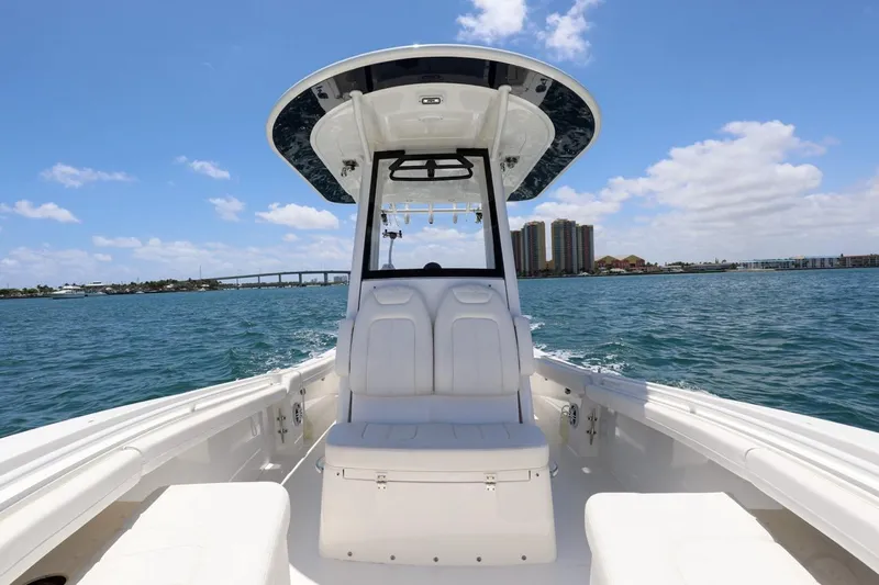  Yacht Photos Pics 2024 Regulator 23 boat on water, clear sky, bridge and buildings in background.