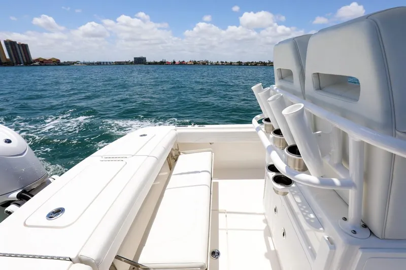  Yacht Photos Pics 2024 Regulator 23 boat interior with seating and rod holders, overlooking a scenic ocean view.