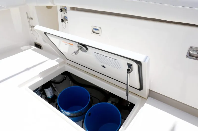  Yacht Photos Pics 2024 Regulator 23 boat storage compartment with open lid and blue buckets inside.