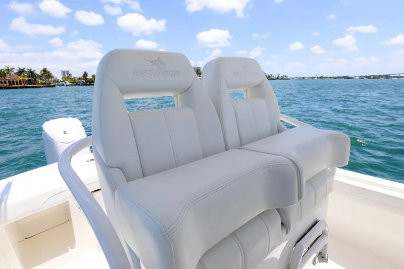  Yacht Photos Pics 2024 Regulator 23 boat with white cushioned seats on a sunny day at sea.