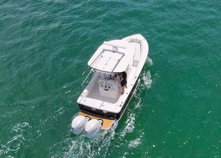  Yacht Photos Pics 2024 Regulator 23 boat cruising on clear turquoise water, aerial view.