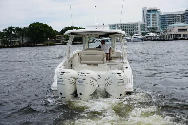 Iboat 3 Yacht Photos Pics 2019 Boston Whaler 350 Realm boat cruising on a river near a marina.