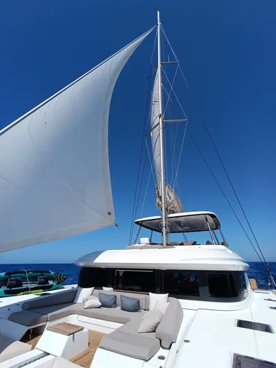 Esperance Yacht Photos Pics 2024 Lagoon 55 yacht with sails up, featuring a luxurious deck under clear blue skies.