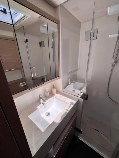 Esperance Yacht Photos Pics 2024 Lagoon 55 yacht bathroom with modern sink and glass shower enclosure.