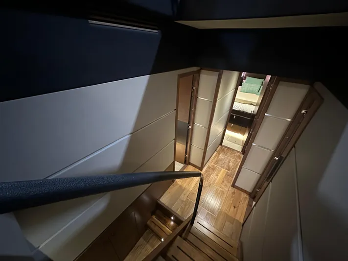 Flawless Yacht Photos Pics Interior view of 2015 Sea Ray L650 Fly yacht, featuring elegant wooden stairs and hallway.