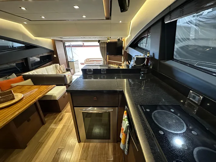 Flawless Yacht Photos Pics Luxurious interior of 2015 Sea Ray L650 Fly yacht with modern kitchen and seating area.