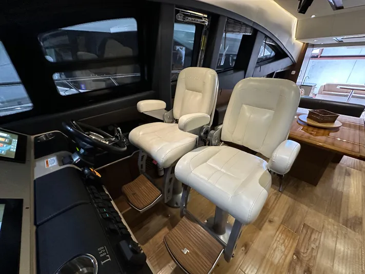 Flawless Yacht Photos Pics Interior of 2015 Sea Ray L650 Fly yacht with plush captain chairs and wooden flooring.