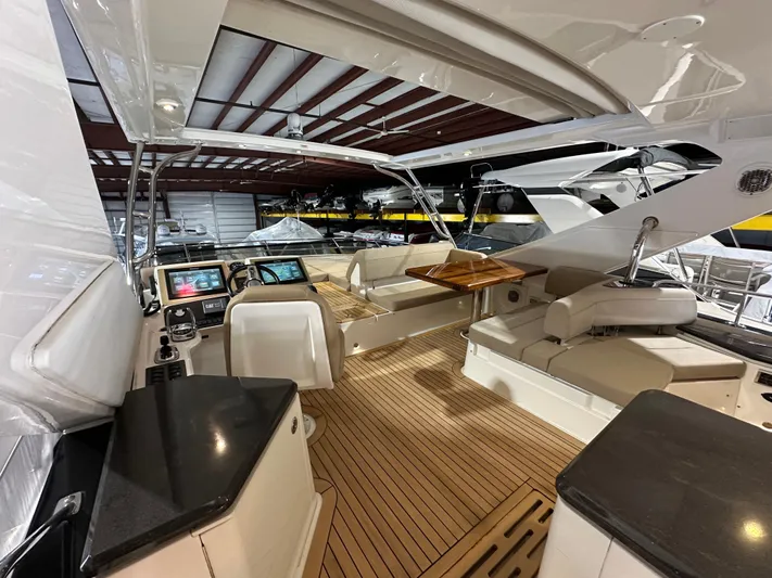 Flawless Yacht Photos Pics 2015 Sea Ray L650 Fly yacht interior with modern helm, seating, and wooden flooring.