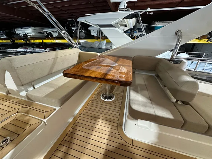 Flawless Yacht Photos Pics 2015 Sea Ray L650 Fly yacht interior with wooden table and cushioned seating.
