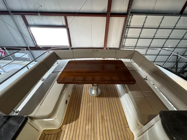 Flawless Yacht Photos Pics 2015 Sea Ray L650 Fly yacht interior with wooden table and cushioned seating.
