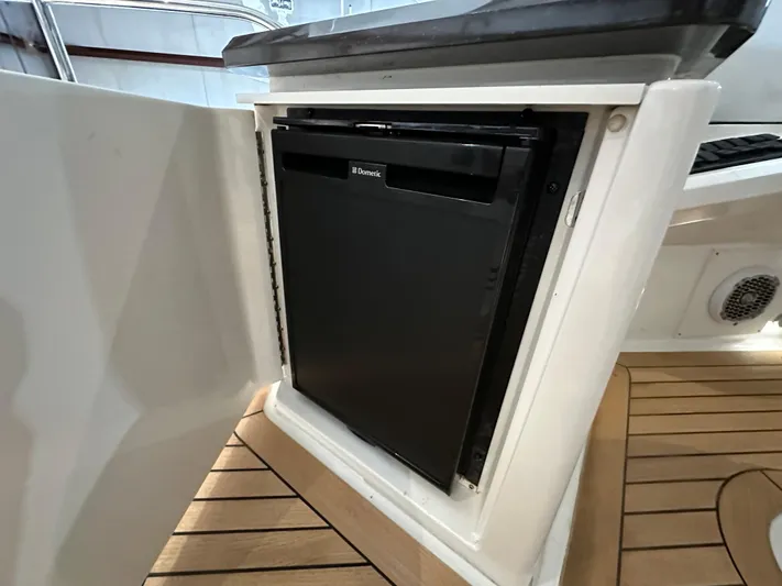 Flawless Yacht Photos Pics Built-in fridge on 2015 Sea Ray L650 Fly yacht, open cabinet view.