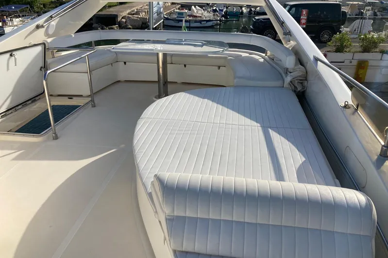  Yacht Photos Pics 2004 Ferretti Yachts 590 flybridge with white cushioned seating and table.