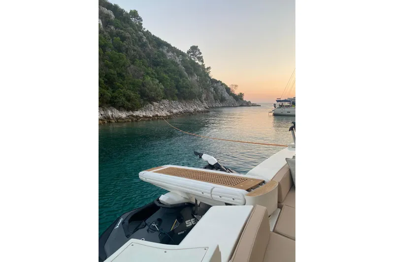  Yacht Photos Pics 2004 Ferretti Yachts 590 at sunset, docked near a rocky shoreline.