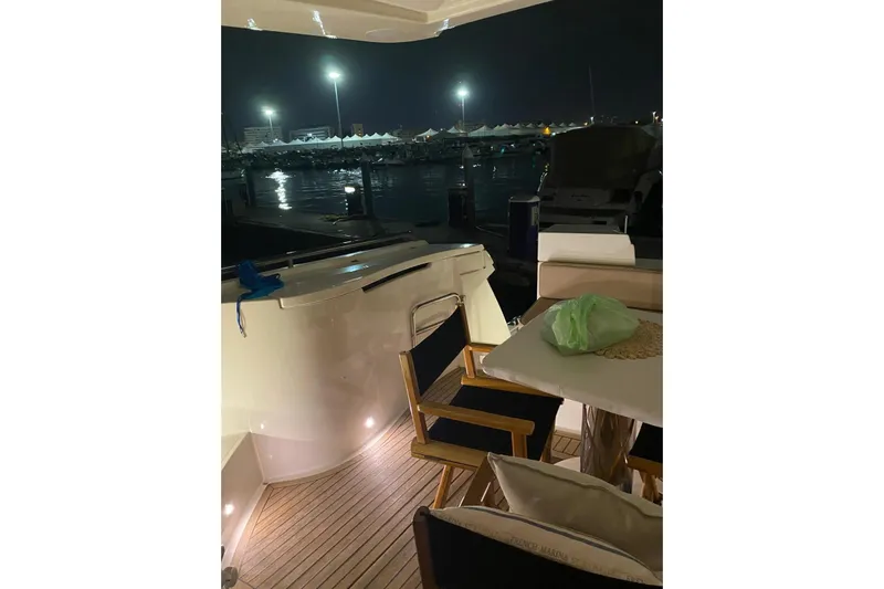  Yacht Photos Pics 2004 Ferretti Yachts 590 at night, featuring a cozy deck with chairs and table.