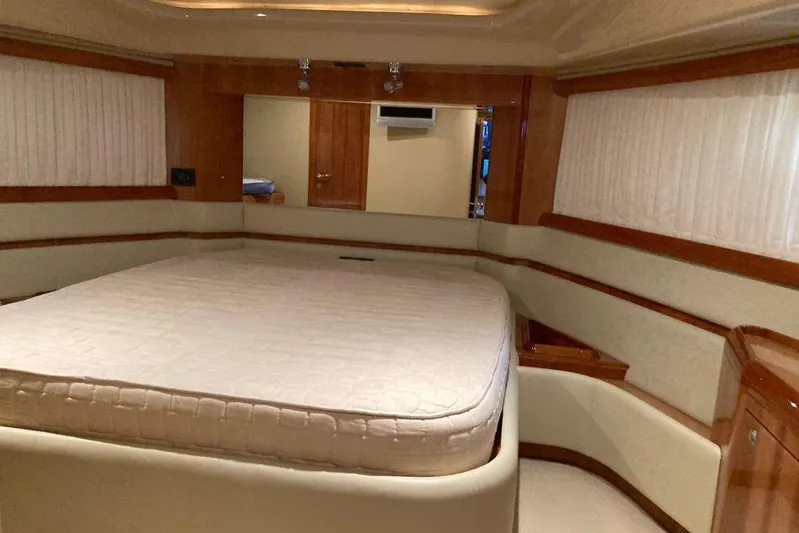  Yacht Photos Pics Luxurious bedroom interior of 2004 Ferretti Yachts 590 with elegant wood finishes.