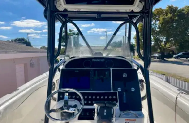  Yacht Photos Pics 2006 Wellcraft 32 CCF boat dashboard with steering wheel and controls under clear blue sky.